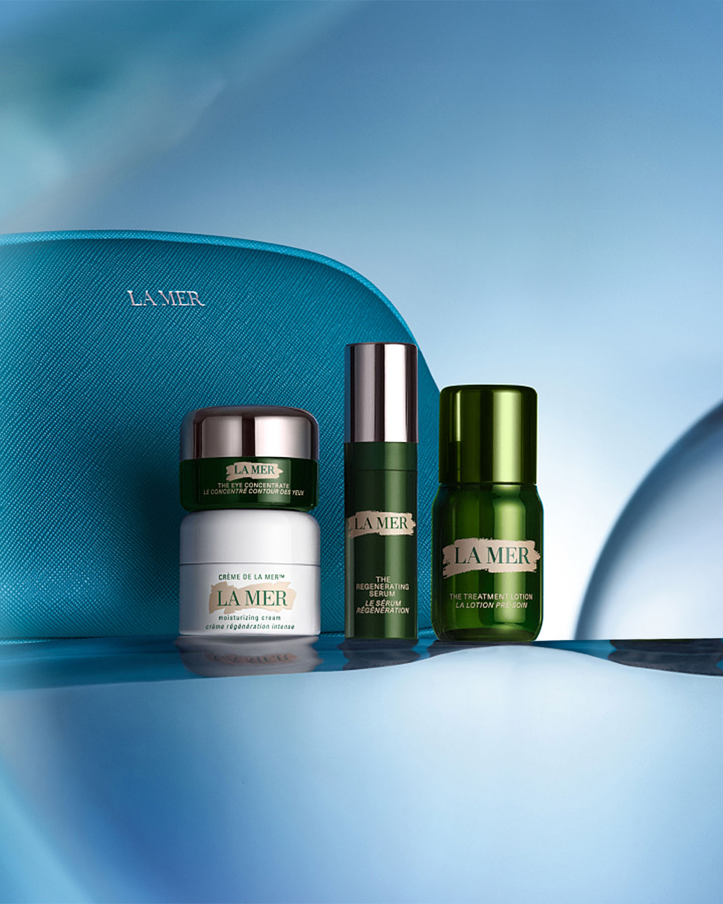 A selection of La Mer deluxe minis featured in the 4-piece gift floating on top of a smooth blue wave.