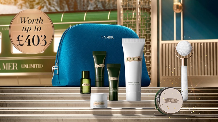 5 deluxe La Mer minis in front a blue cosmetic bag, with animating complimentary accessories and full-size lip products