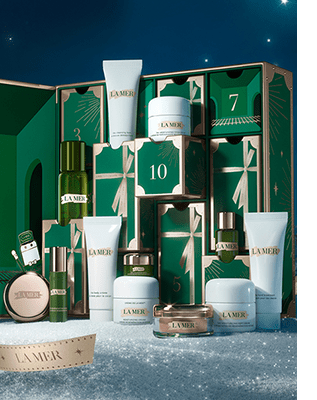 The 2024 La Mer Advent Calendar nested in snow in front of a clear winter night sky